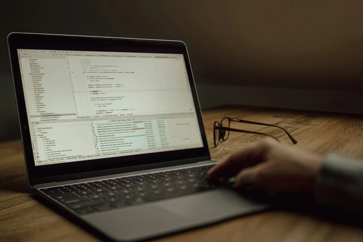 コードを表示したノートパソコンで作業する手元